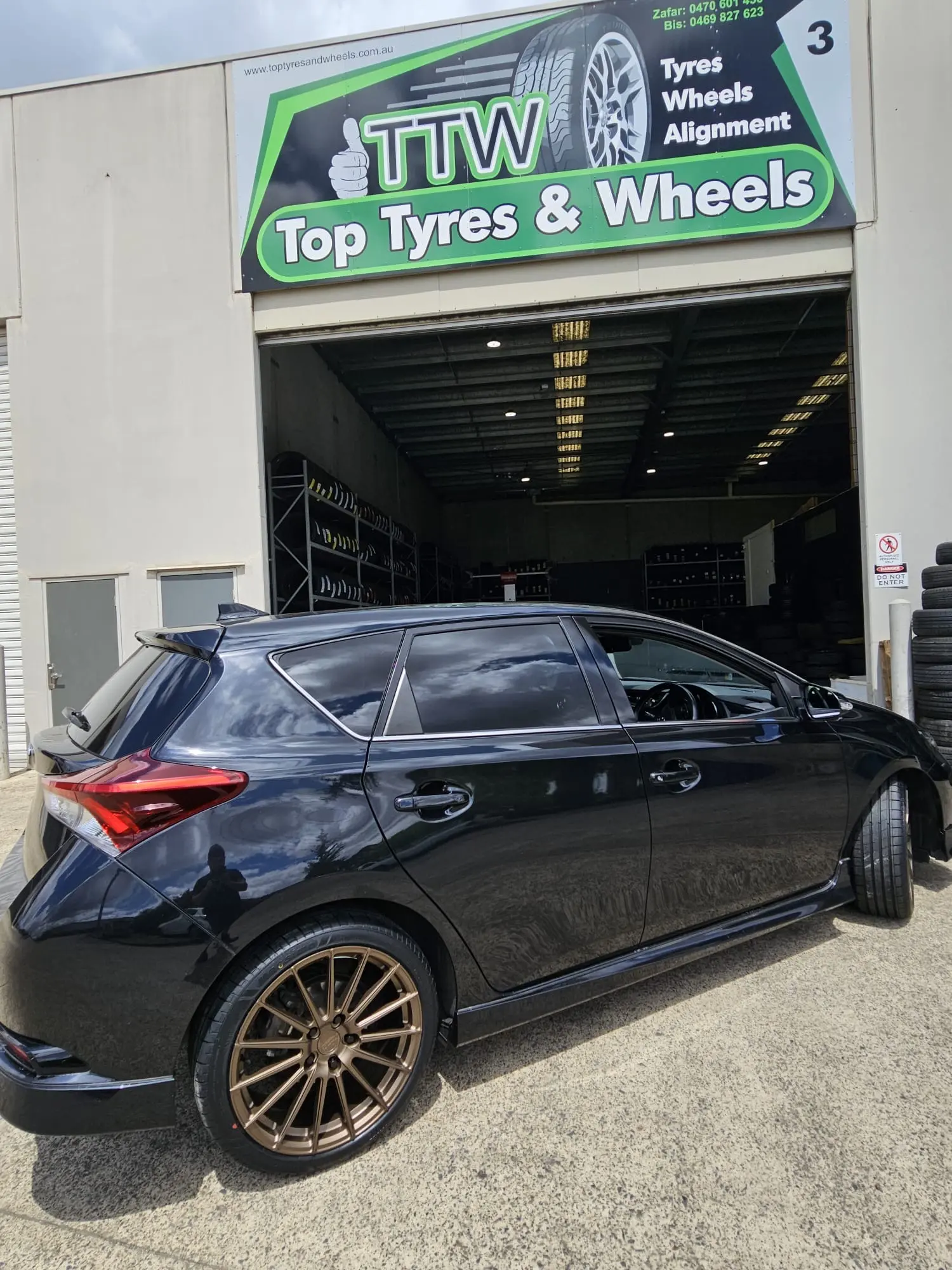 Black hatchback with fitted bronze multi-spoke wheels